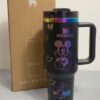 Gourde Stanley Flowstate Tumbler 40 oz avec anse — noir avec motifs multicolores et bande métallique irisée, motif personnage rond assis à grande tête et
