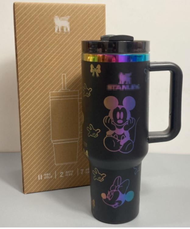 Gourde Stanley Flowstate Tumbler 40 oz avec anse — noir avec motifs multicolores et bande métallique irisée, motif personnage rond assis à grande tête et