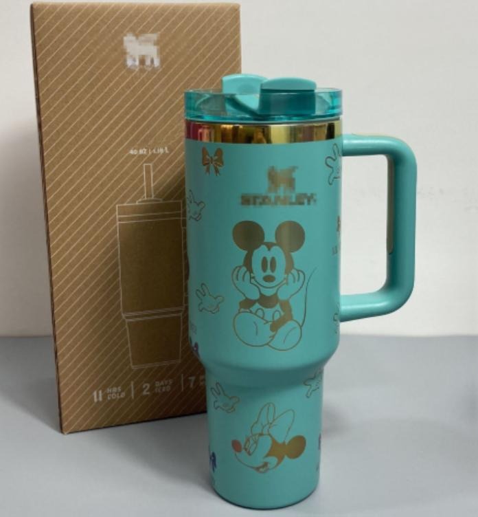 Gourde Stanley Flowstate Tumbler 40 oz avec anse — turquoise avec motifs dorés, motif personnage rond assis à grande tête et