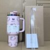 Gourde Stanley Flowstate Tumbler avec anse — rose pâle avec motif dégradé irisé, motif personnage félin stylisé avec noeud