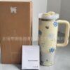 Gourde Stanley Quencher H2.0 Tumbler 30 OZ avec anse — crème, motif fleurs bleues, motif bouquets de petites fleurs bleues avec