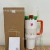 Gourde Stanley Quencher H2.0 Tumbler 40 oz / 1.18 L avec anse — blanc (corps), couvercle vert et rouge, poignée orange