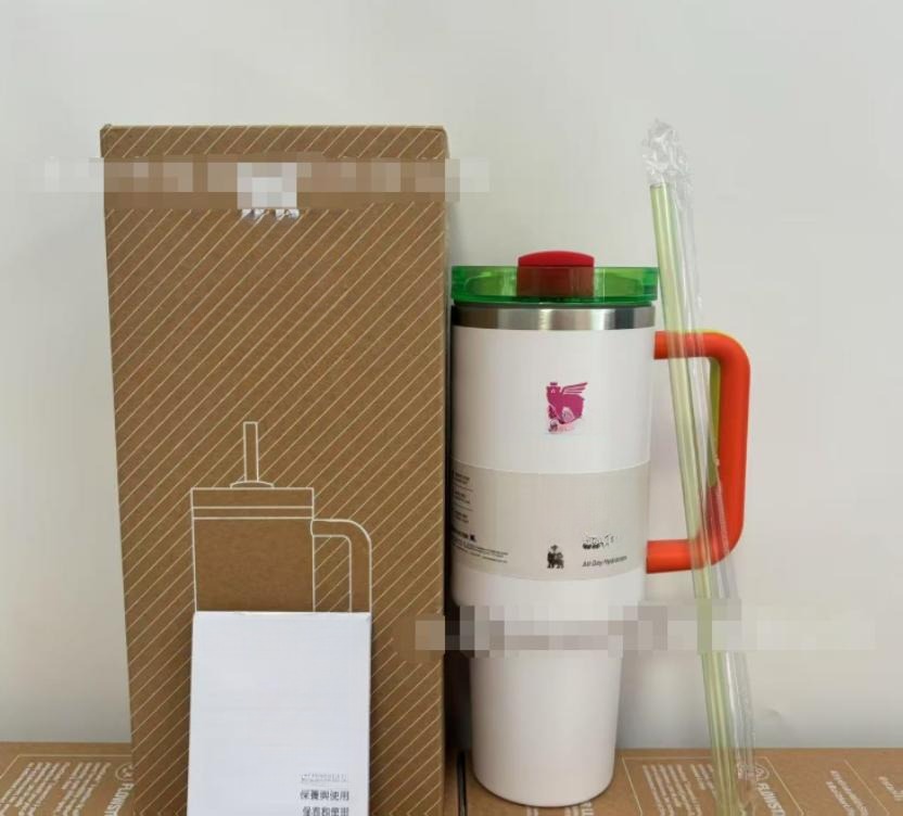 Gourde Stanley Quencher H2.0 Tumbler 40 oz / 1.18 L avec anse — blanc (corps), couvercle vert et rouge, poignée orange