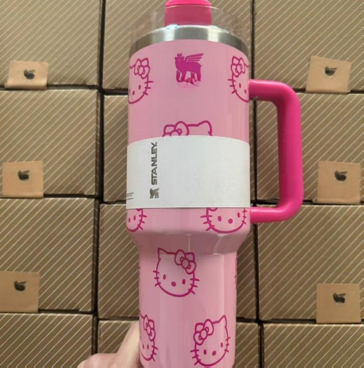 Gourde Stanley Quencher H2.0 Tumbler 40 OZ | 1.18 L avec anse — rose pâle avec motif blanc/rose foncé, motif personnage félin blanc stylisé avec noeud