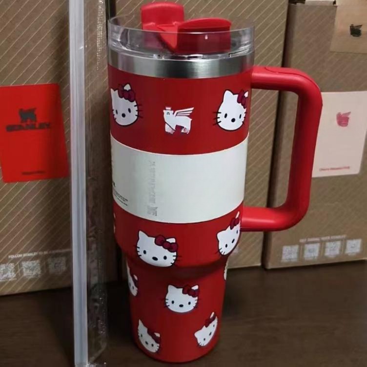 Gourde Stanley Quencher H2.0 Tumbler 40 OZ | 1.18 L avec anse — rouge avec motif blanc, motif personnage félin blanc stylisé avec noeud
