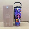 Gourde Stanley Quencher H2.0 Tumbler 40 OZ / 1.18L avec anse — violet, motif personnage féminin en veste orange