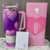 Gourde Stanley Quencher H2.0 Tumbler 40 OZ (partiellement lisible) avec anse — dégradé violet à rose, motif cœurs, motif grands motifs de cœurs superposés en dégradé