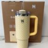 Gourde Stanley Quencher Tumbler avec anse — jaune et blanc, motif géométrique en damier avec fleurs