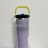Gourde Stanley Quencher Tumbler avec anse — mauve / lilas, anse jaune fluo, couvercle noir, motif géométrique de petits triangles en