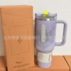 Gourde Stanley Quencher Tumbler avec anse — mauve / lilas, anse mauve, bouton jaune fluo, motif géométrique de petits triangles en