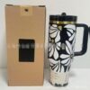 Gourde Stanley Quencher Tumbler avec anse — noir, motif fleurs blanches et jaunes, motif de marguerites blanches à cœur jaune