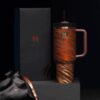 Gourde Stanley Quencher Tumbler avec anse — orange/marron avec reflets métalliques, motif rayures tigrées diagonales