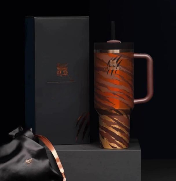 Gourde Stanley Quencher Tumbler avec anse — orange/marron avec reflets métalliques, motif rayures tigrées diagonales
