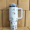 Gourde Stanley Quencher Tumbler vide avec anse — bleu clair / lavande pâle, motif mêmes scènes en contours foncés : chien