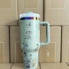 Gourde Stanley Quencher Tumbler vide avec anse — vert sauge clair, motif mêmes scènes en contours foncés : chien